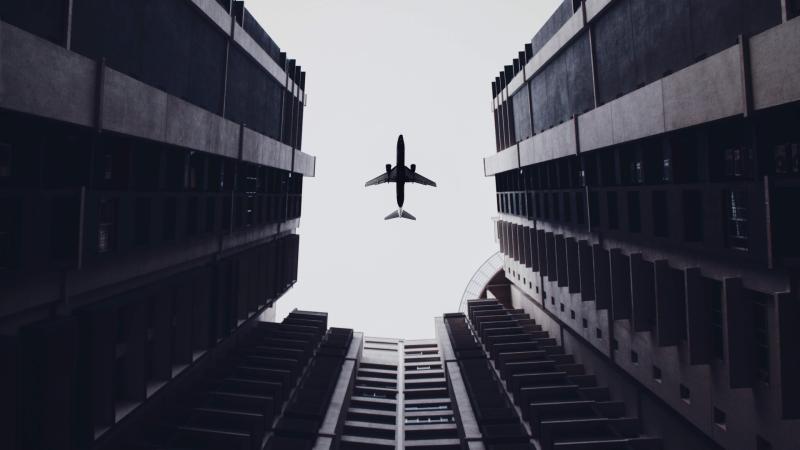 Airplane Flying Above The Buildings 5k