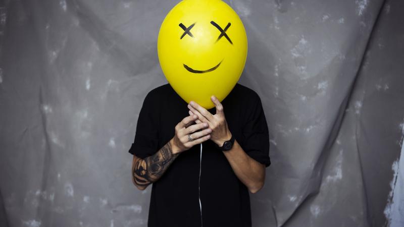 Boy With Smiley Balloon On Face