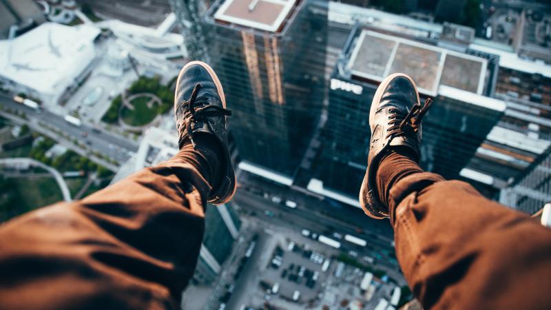 Man Sitting On Top Of A Rooftop