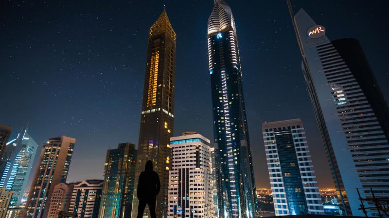 Man Standing Front Of Tall Buildings