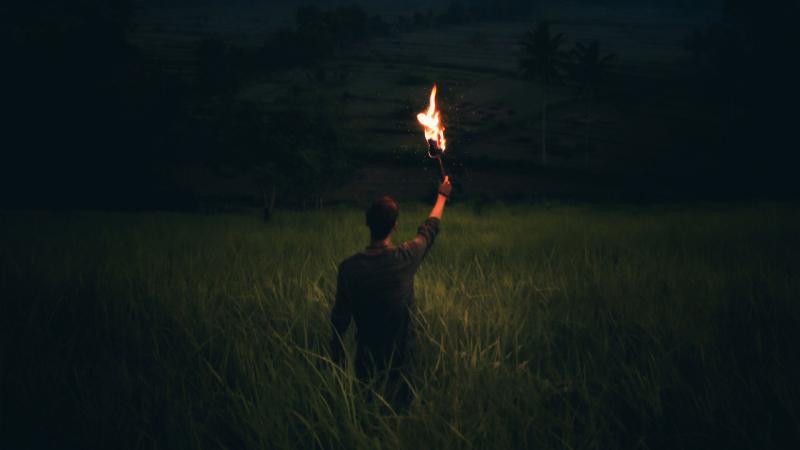 Man Through Dark With Wooden Torch