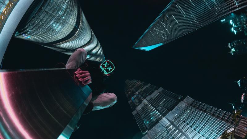 Mask Guy Sitting Behind Buildings