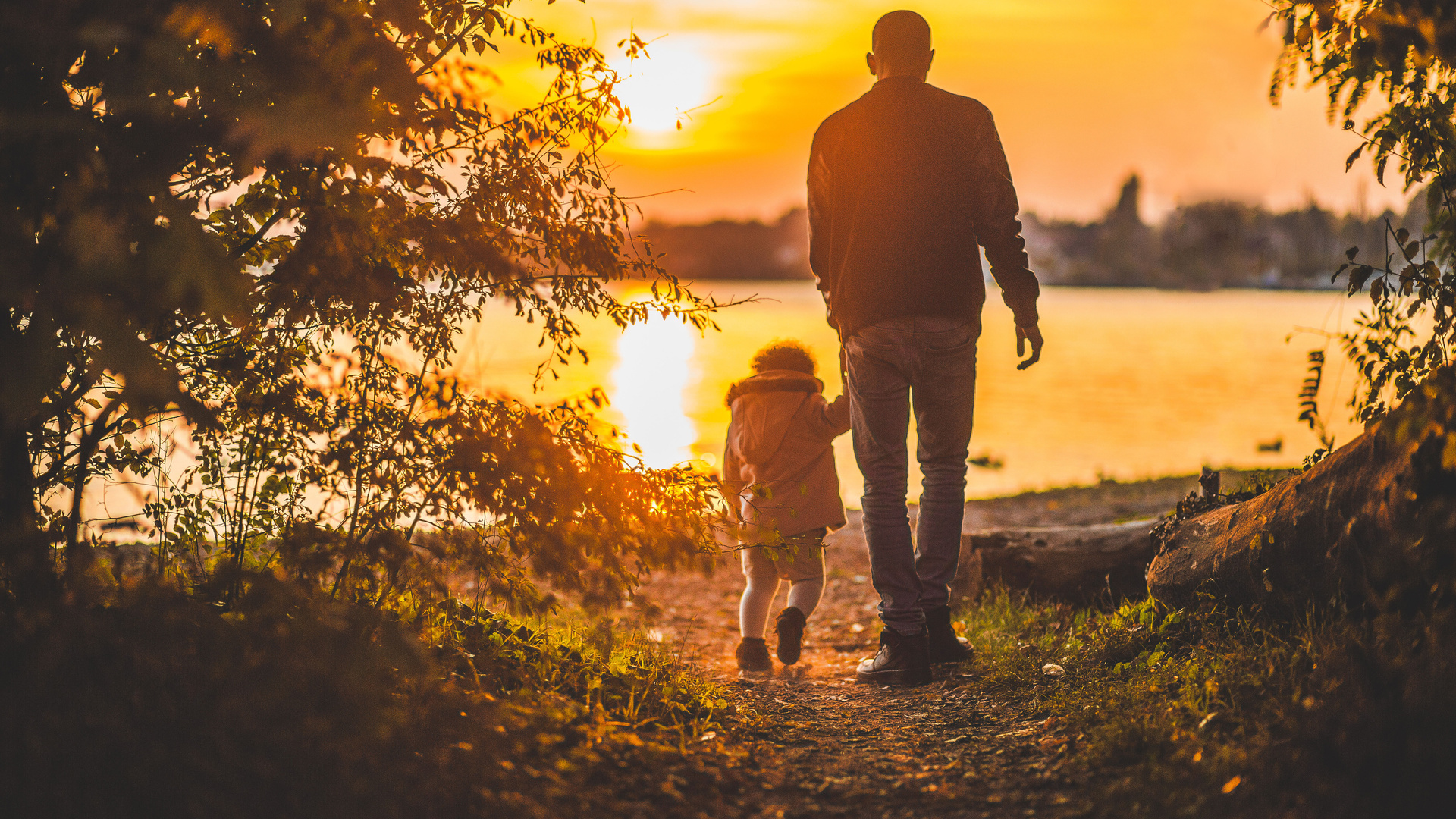 Father And Kid Walking Towards Lake