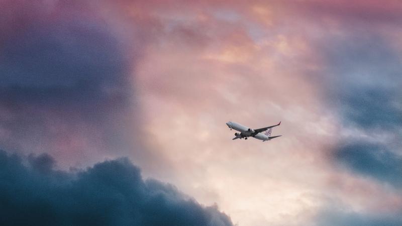 Passenger Plane In Clouds View From Far Away